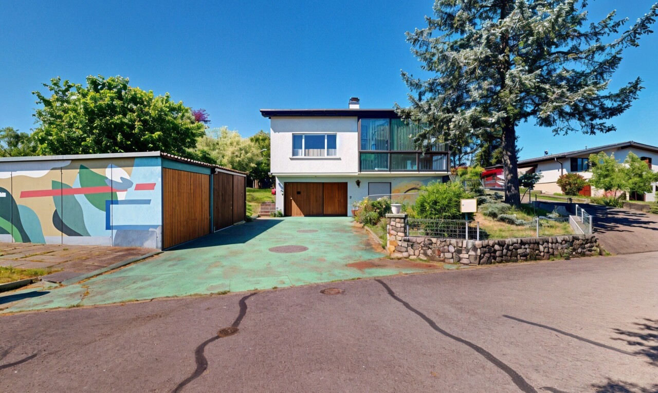 view of home featuring driveway and a chimney