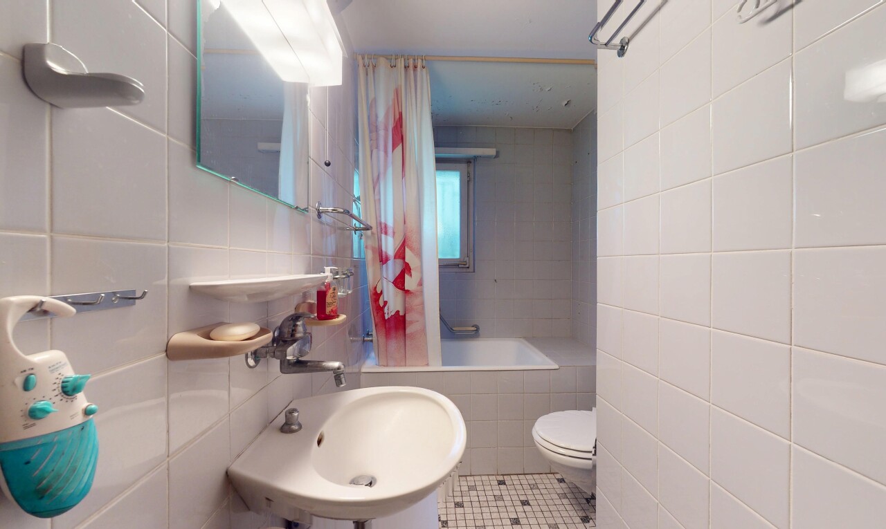 bathroom featuring tile walls, toilet, tile patterned floors, tiled shower / bath, and a sink
