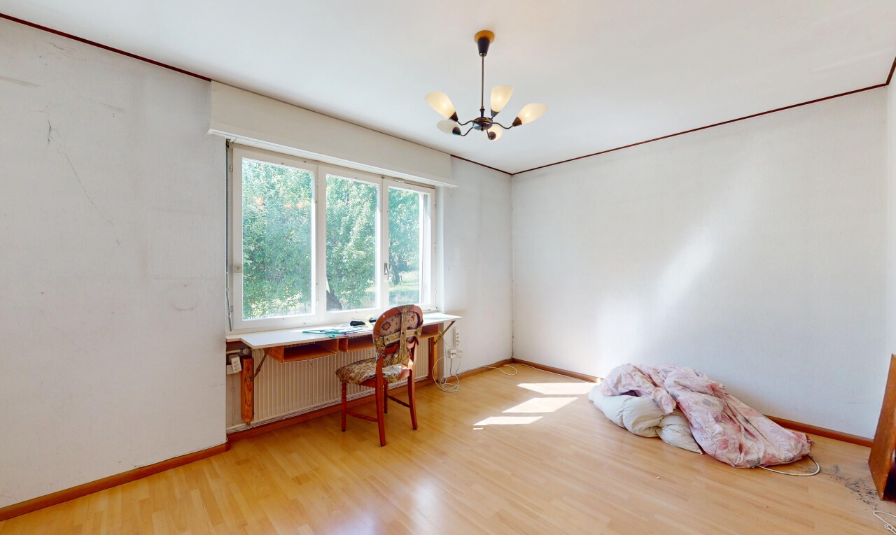 room with a chandelier, light wood-style flooring, radiator heating unit, and baseboards
