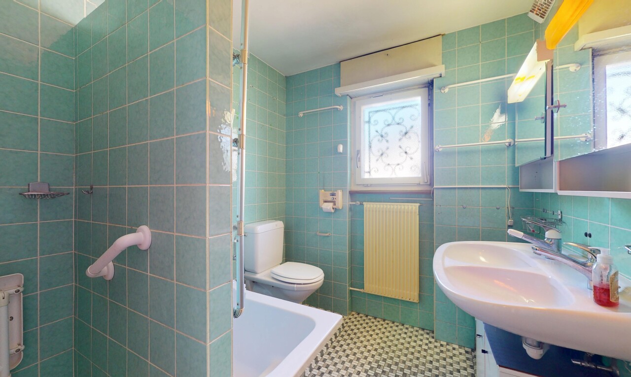 bathroom featuring radiator, tile walls, a sink, and toilet