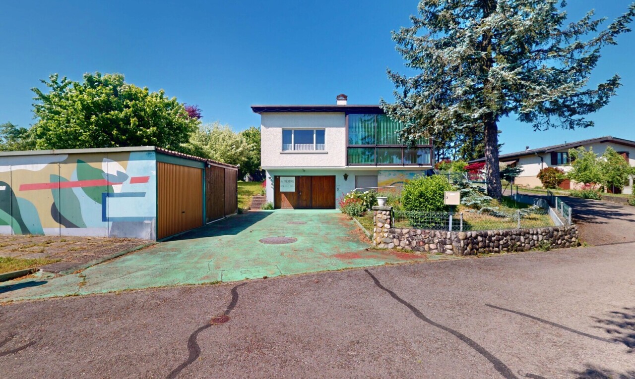 view of home featuring driveway and a chimney
