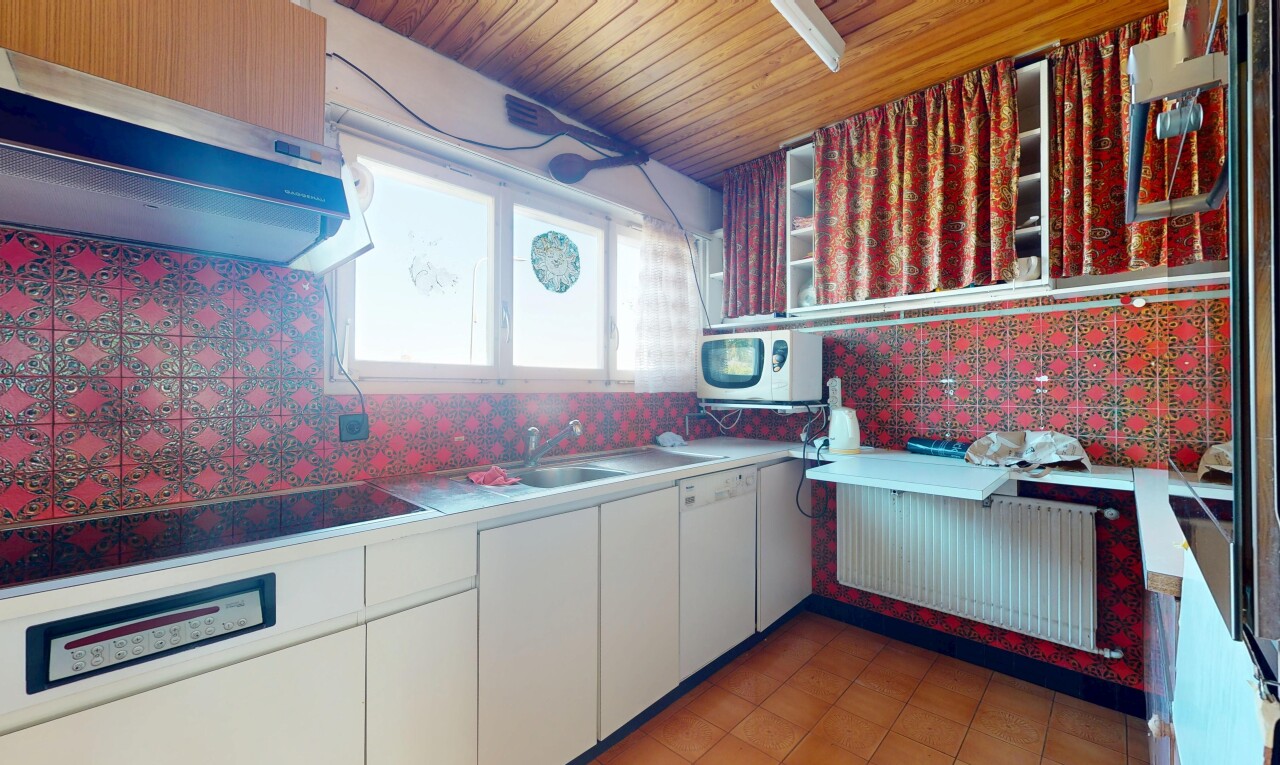 kitchen featuring under cabinet range hood, white appliances, a sink, white cabinetry, and backsplash