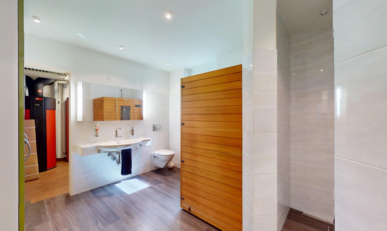 bad mit toilette, wood finish floor, holzfußboden, inside property, und spiegel