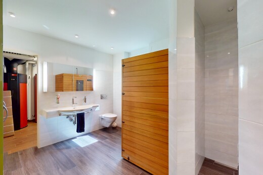 salle de bains avec toilette, wood finish floor, sol en finition bois, inside property, et miroir