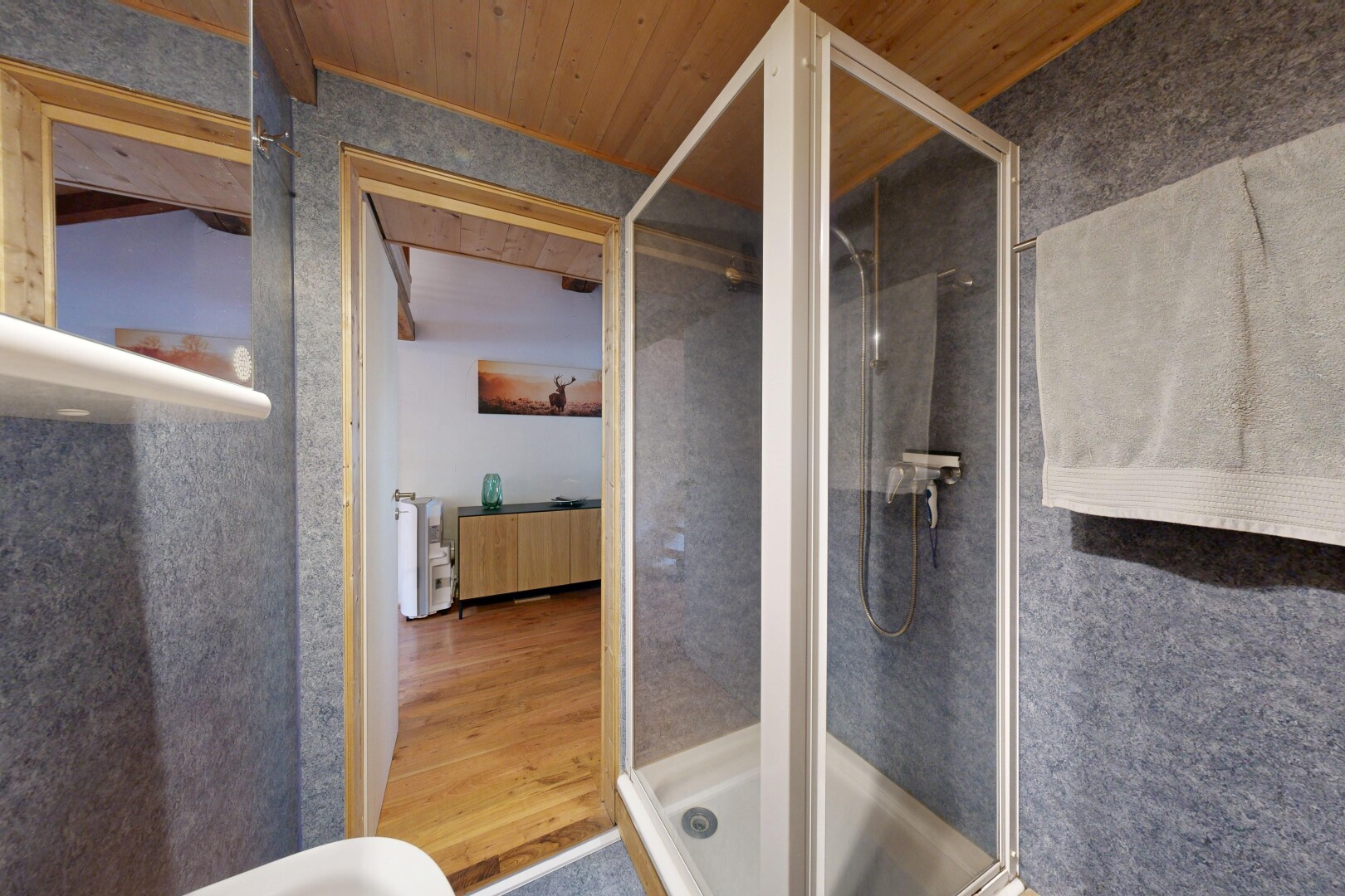 bathroom with a shower stall and wooden ceiling