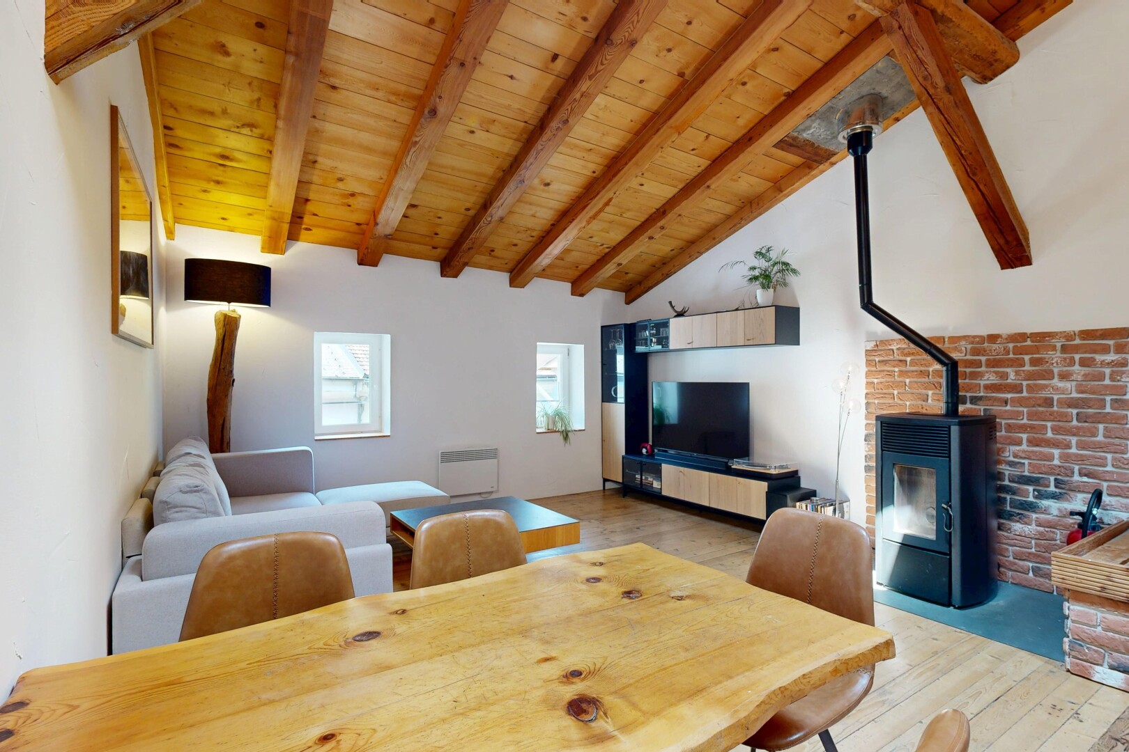 living room with a high wooden beamed ceiling and light wood-type flooring