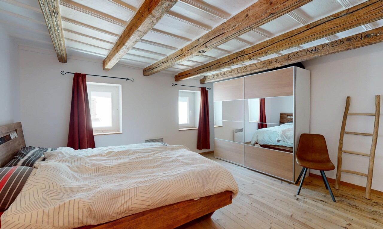 room with beam ceiling, light wood-type flooring, and a closet