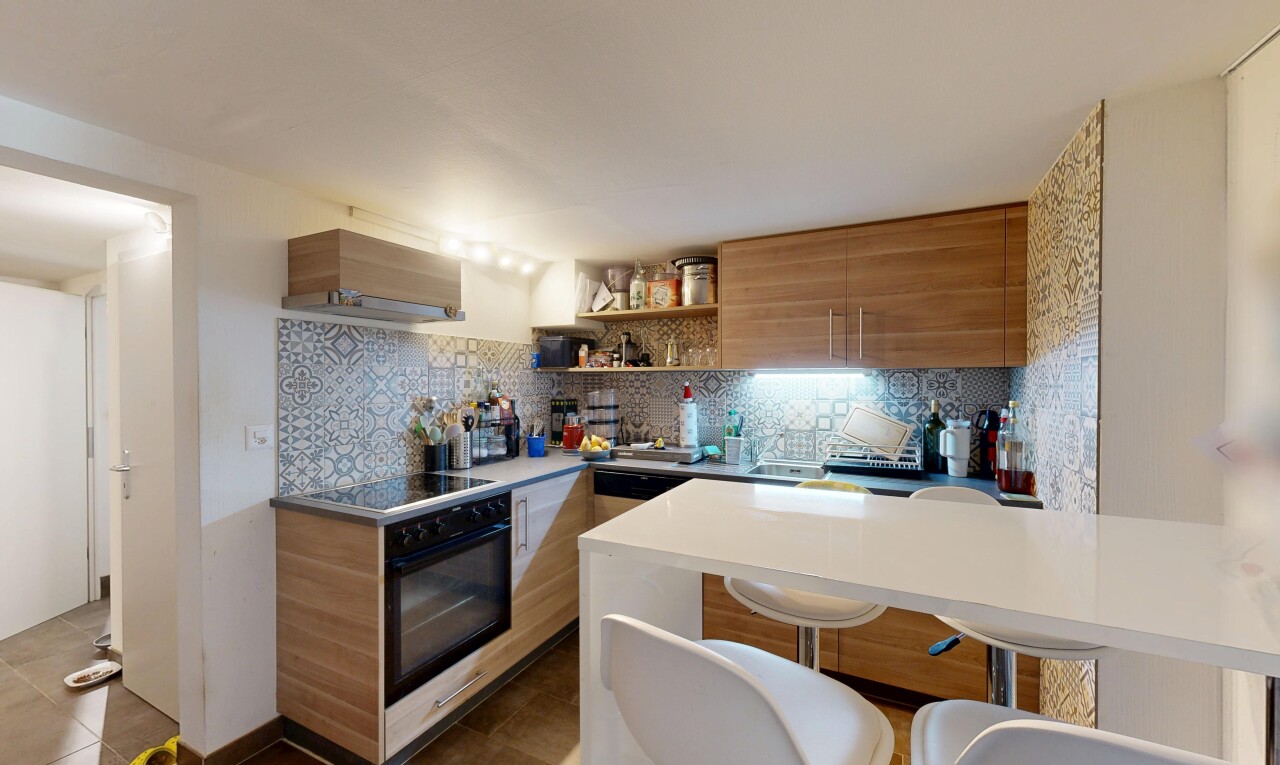 kitchen featuring modern cabinets, wood finish cabinets, decorative backsplash, open shelves, and a kitchen bar