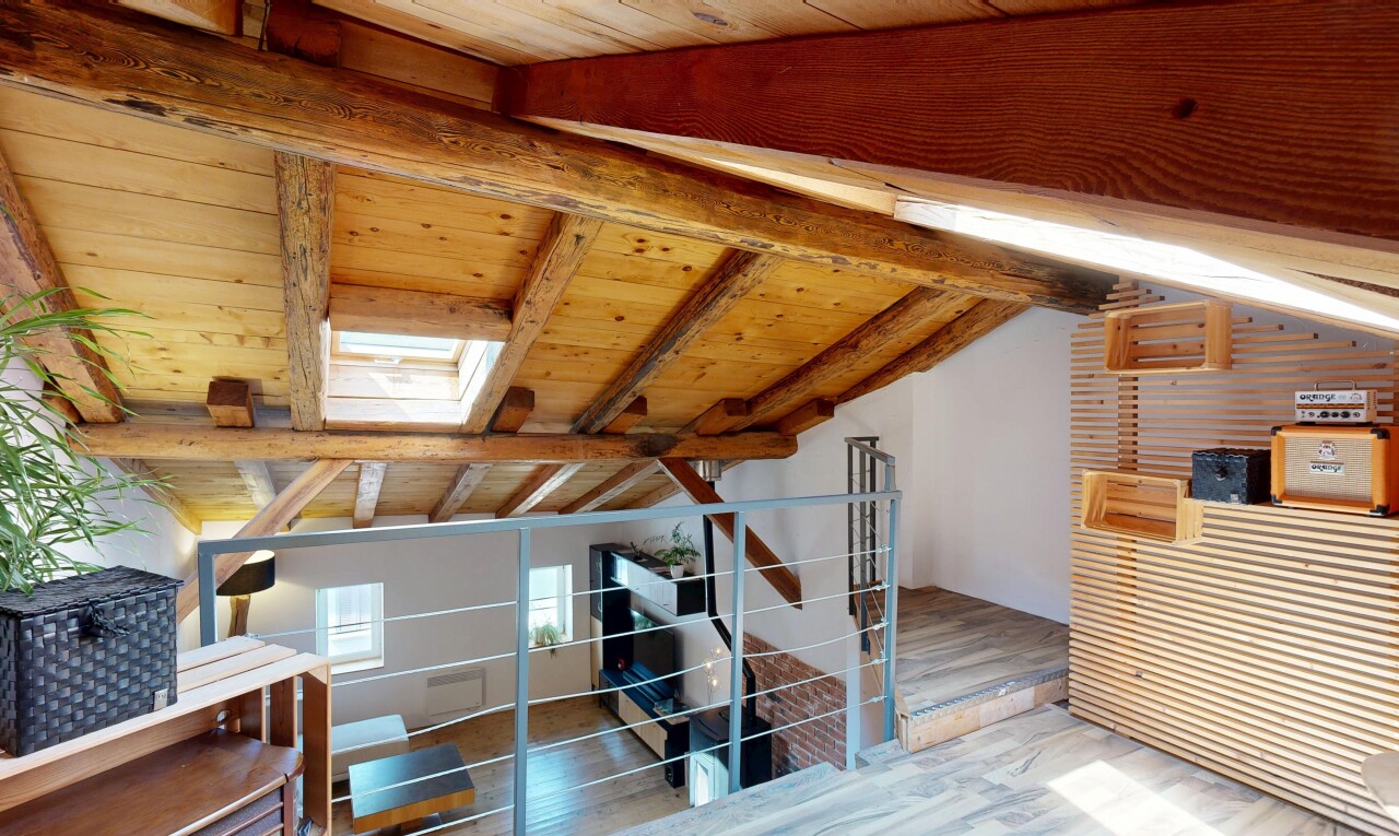 staircase with a skylight, a wood ceiling with exposed beams, and wood finished floors