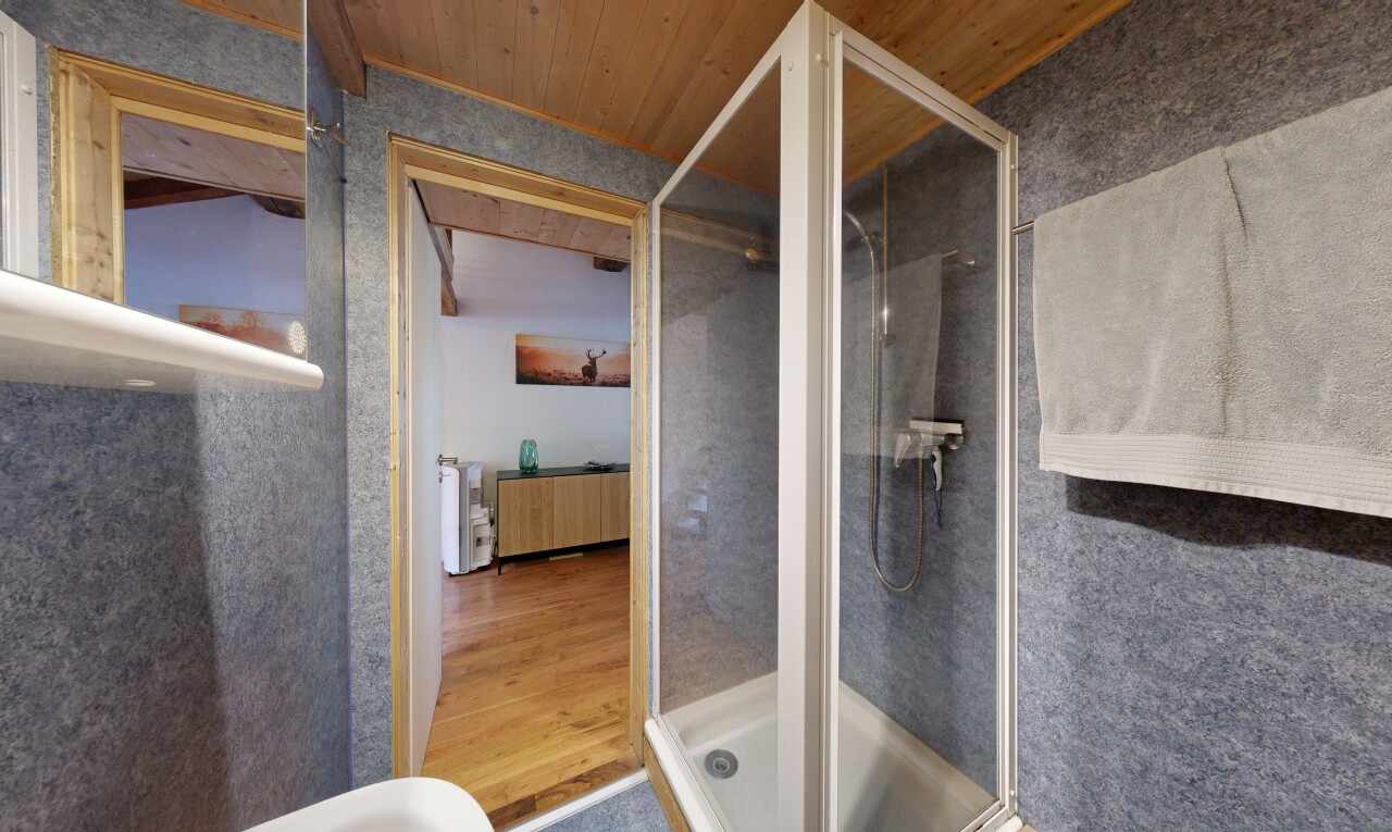 bathroom with a shower stall and wooden ceiling