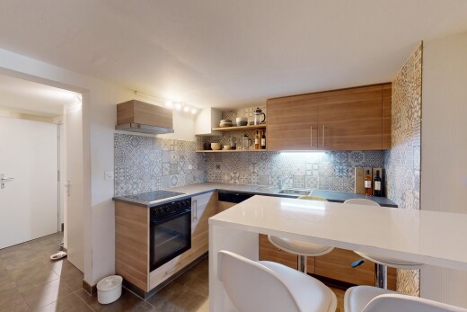 kitchen featuring modern cabinets, wood finish cabinets, decorative backsplash, open shelves, and a kitchen bar