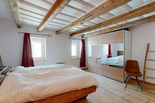 room with beam ceiling, light wood-type flooring, and a closet