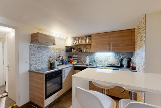 kitchen featuring modern cabinets, wood finish cabinets, decorative backsplash, open shelves, and a kitchen bar