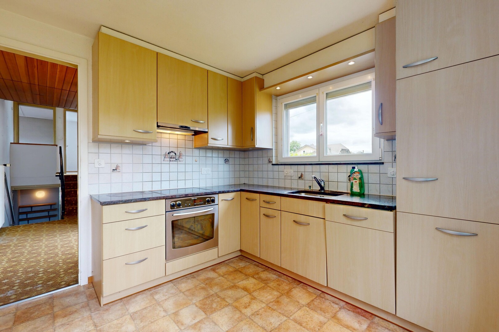 küche mit dark countertops, arbeitsplatten, light brown cabinets, hellbraune schränke, und ofen