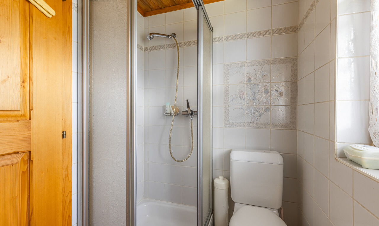 salle de bains avec douche, salle de bain complète, toilette, inside property, et mur en carrelage