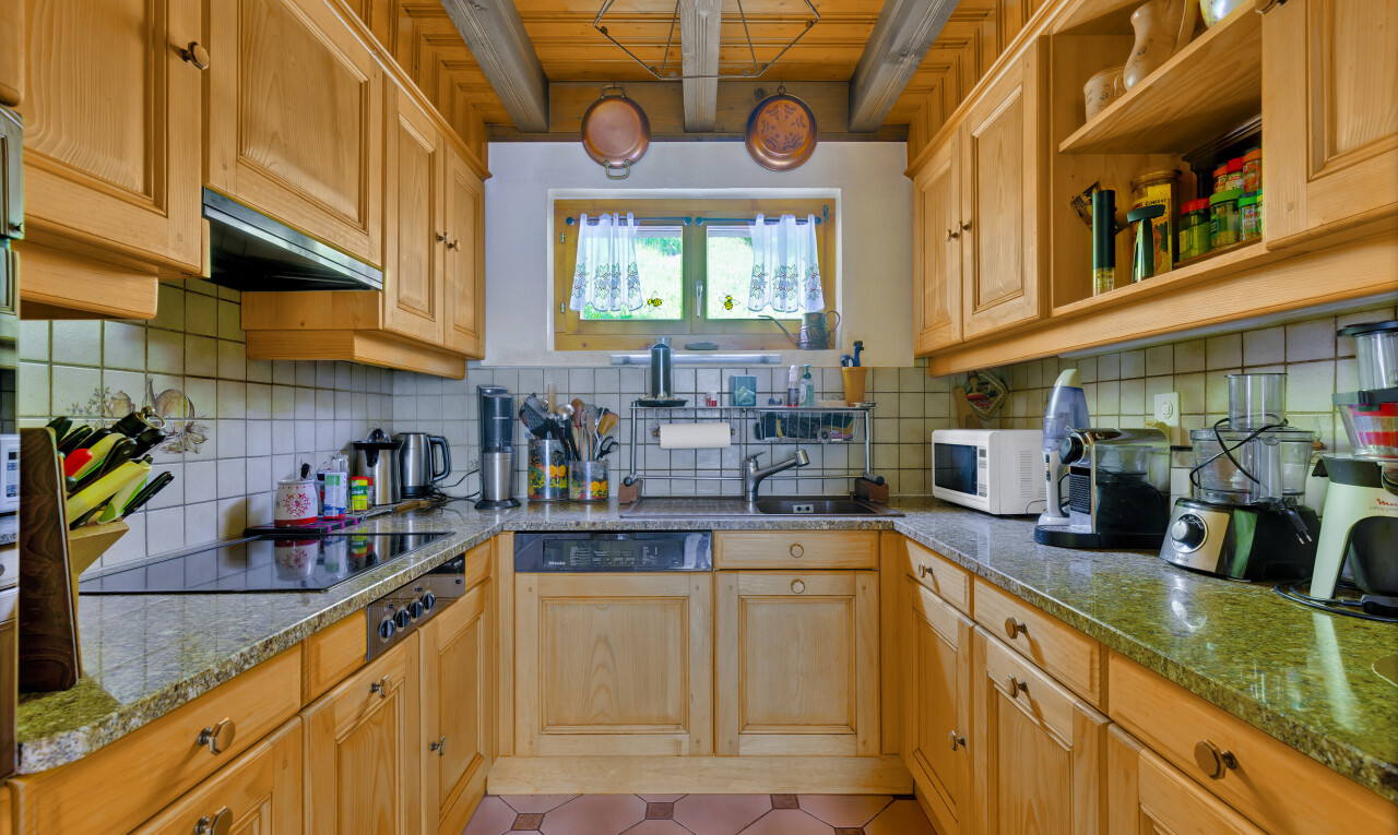 cuisine avec dosseret, backsplash, inside property, plaque de cuisson, et plans de travail en pierre