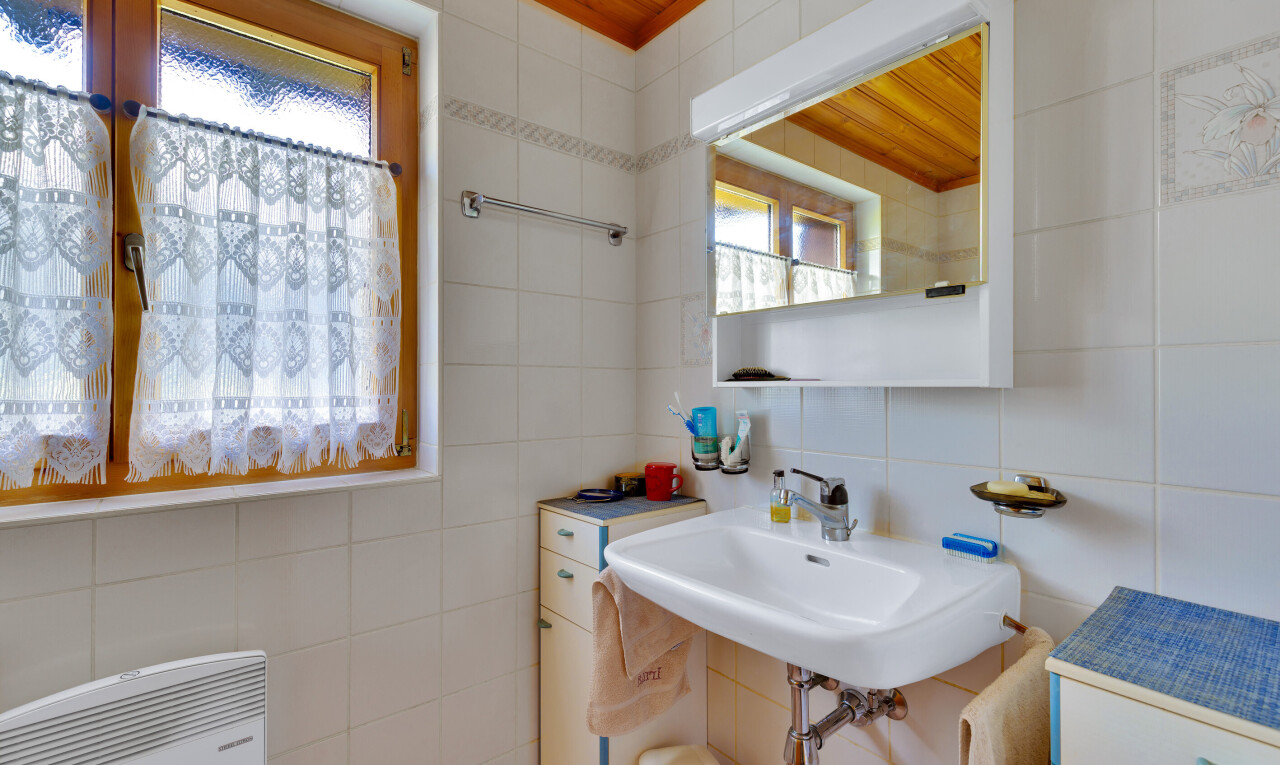 salle de bains avec miroir, mur en carrelage, tile wall, inside property, et évier