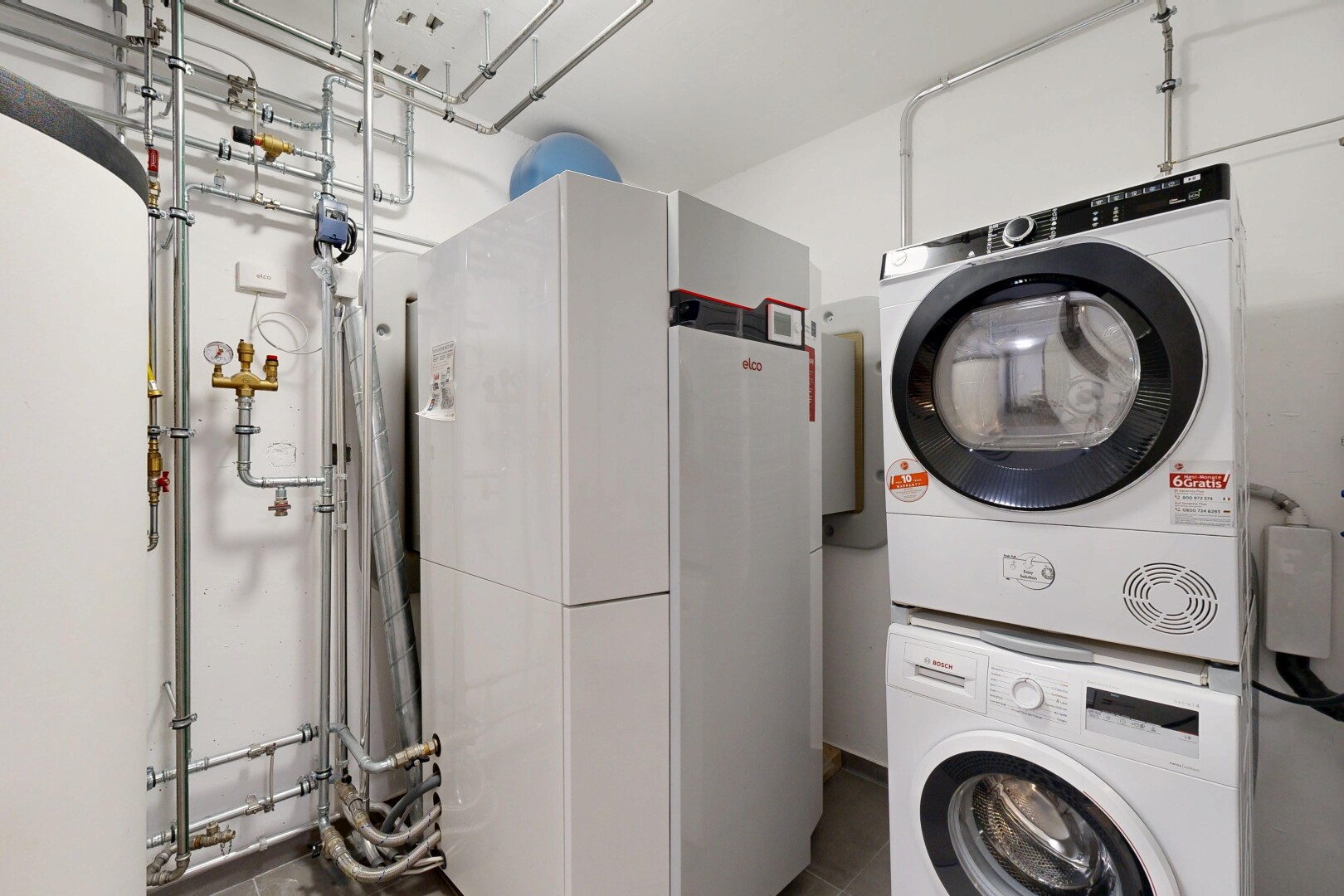 buanderie avec lave-linge et sèche-linge superposés, inside property, buanderie, cloison sèche, et drywall