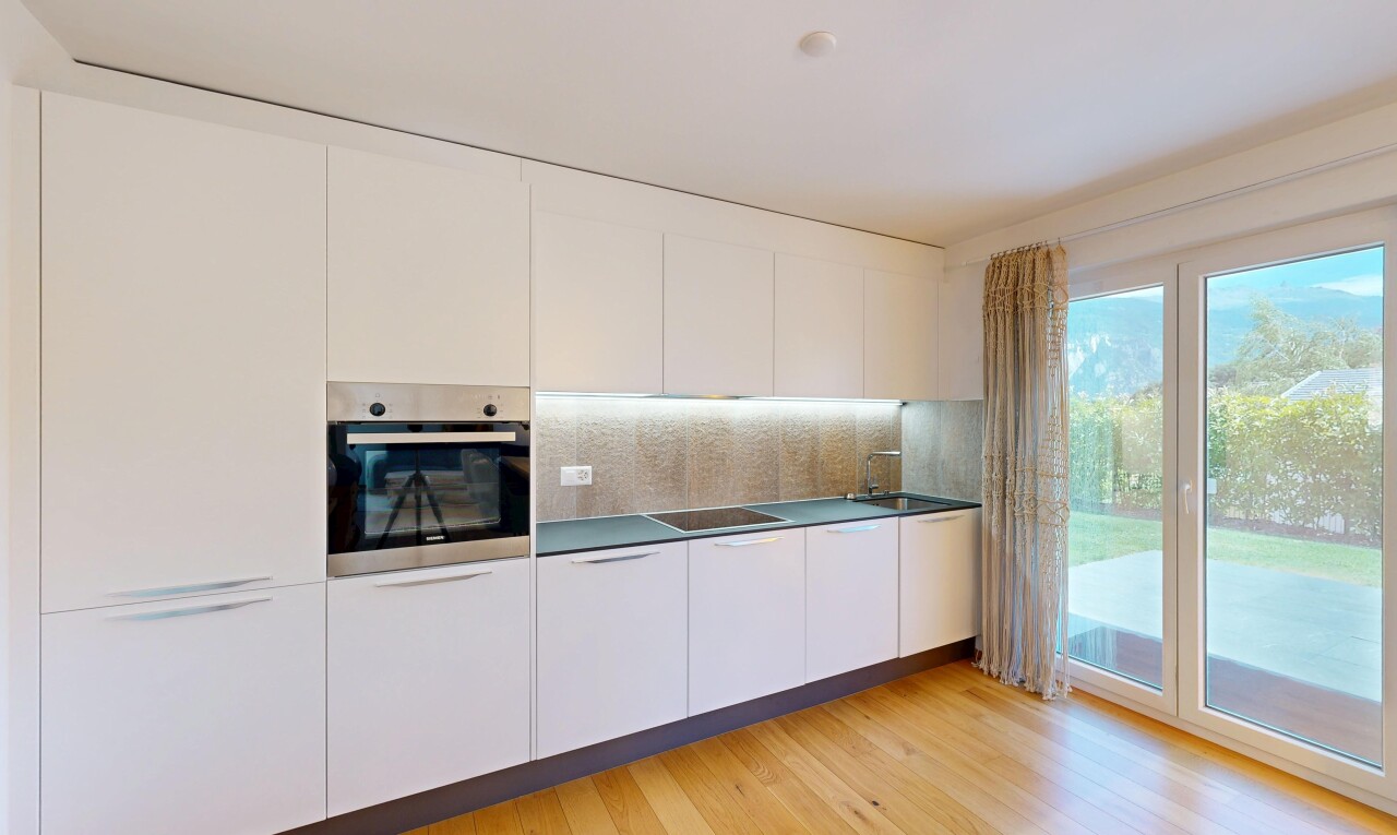 cuisine avec four, light floor, inside property, sol en finition bois, et wood finish floor