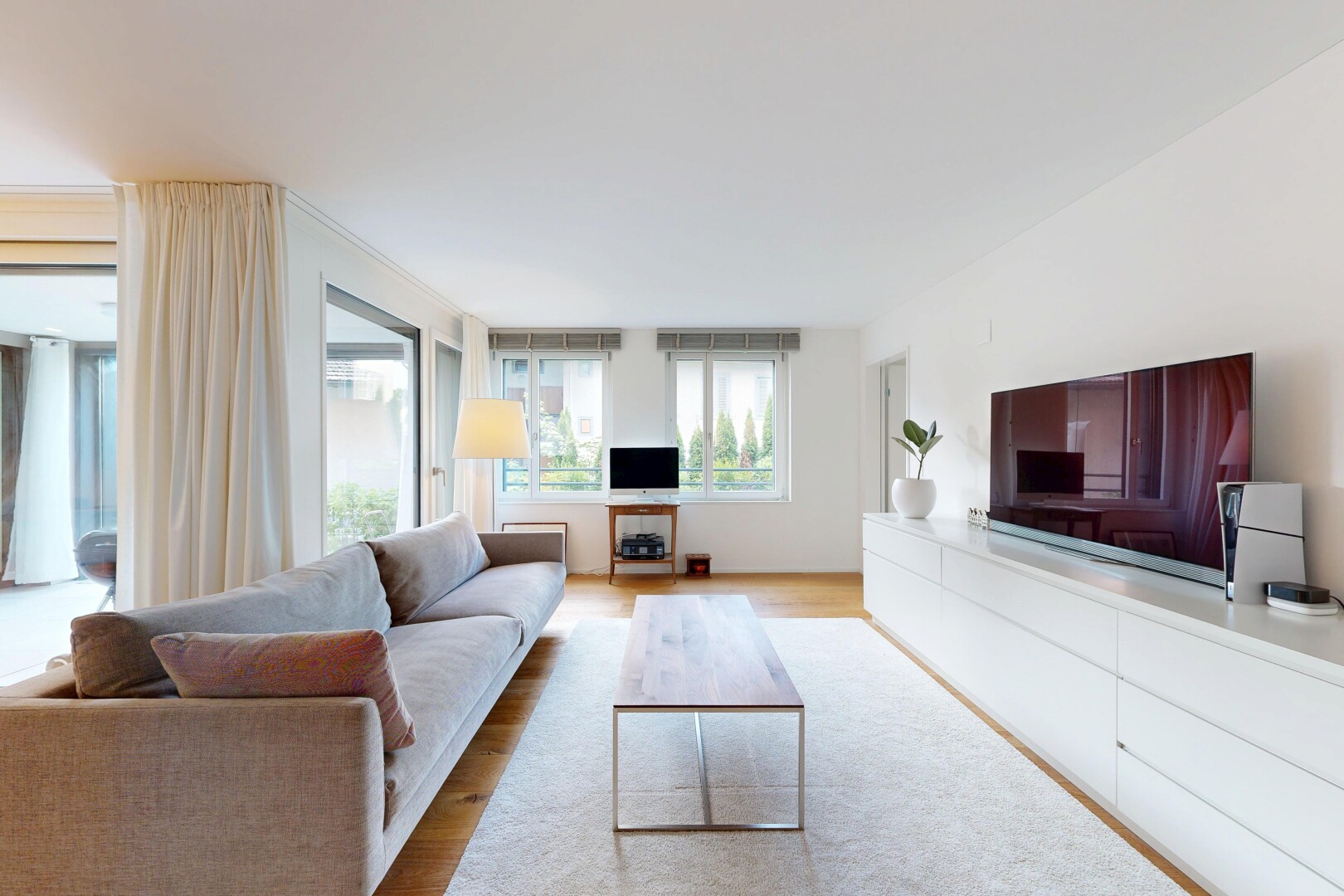 wohnzimmer mit fernseher, holzfußboden, wood finish floor, inside property, und natürliches licht