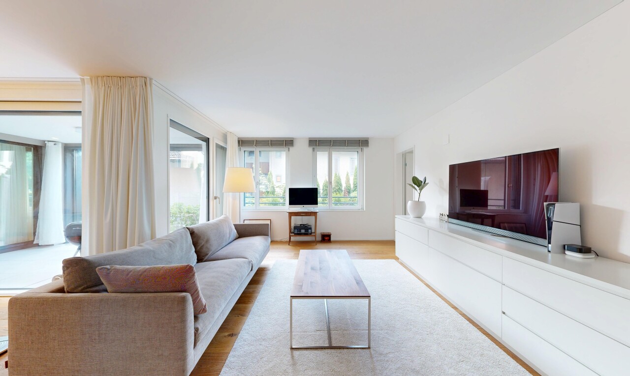 wohnzimmer mit fernseher, holzfußboden, wood finish floor, inside property, und natürliches licht