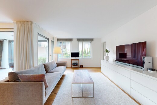 wohnzimmer mit fernseher, holzfußboden, wood finish floor, inside property, und natürliches licht