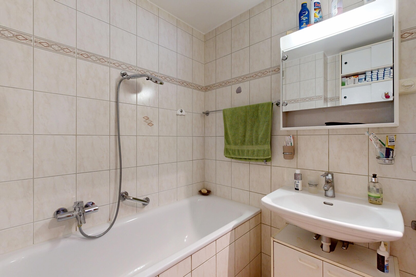 salle de bains avec tile wall, mur en carrelage, miroir, salle de bain complète, et évier