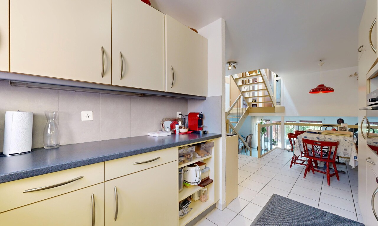 cuisine avec light floor, escaliers, dosseret, backsplash, et sol en carrelage