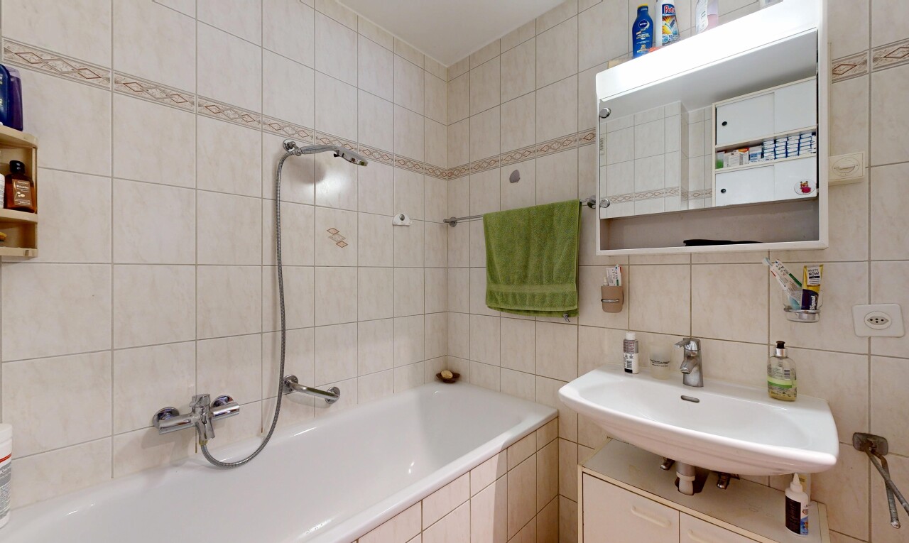 salle de bains avec tile wall, mur en carrelage, miroir, salle de bain complète, et évier