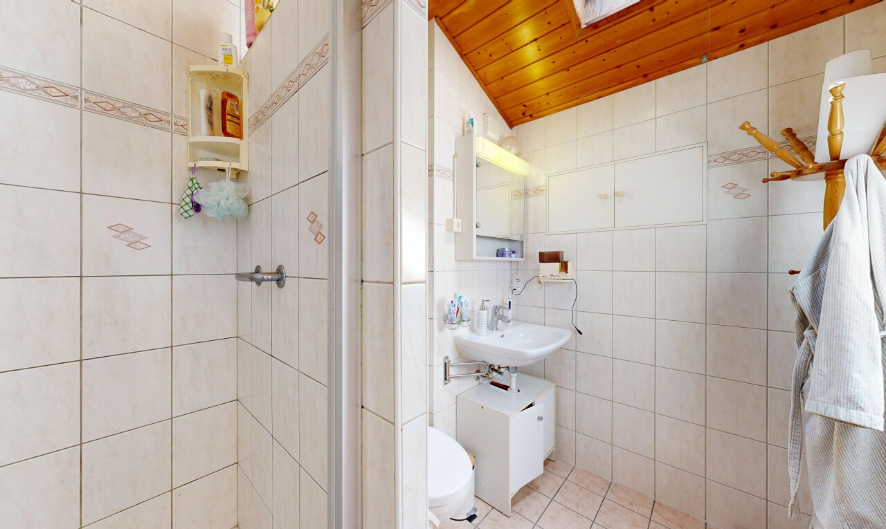salle de bains avec tile wall, mur en carrelage, miroir, salle de bain complète, et toilette