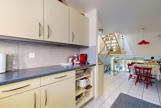 cuisine avec light floor, escaliers, dosseret, backsplash, et sol en carrelage