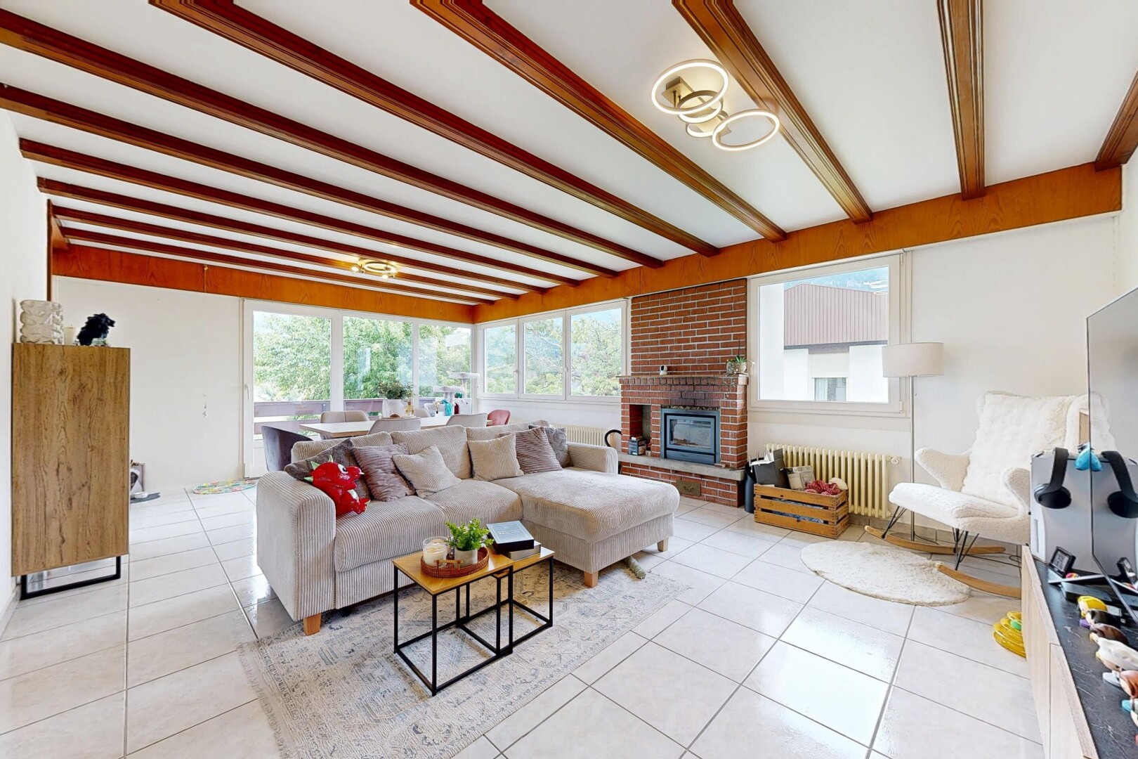salon avec sol en carrelage, tile floor, inside property, plafond à poutres, et beamed ceiling