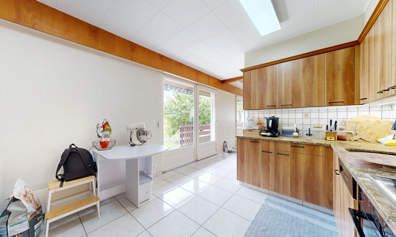 cuisine avec light countertops, light floor, dosseret, backsplash, et inside property