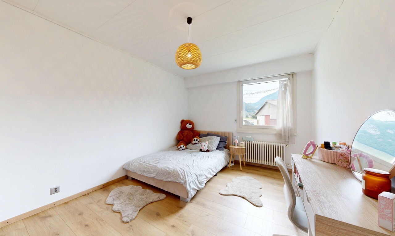 chambre avec sol en finition bois, wood finish floor, radiateur, lumière naturelle, et natural light