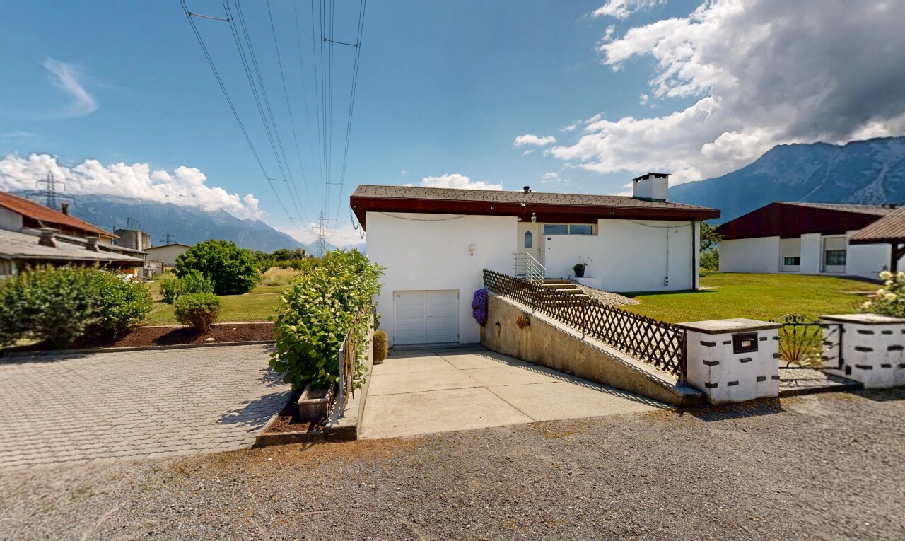façade avec mountain view, vue sur la montagne, allée, garage intégré, et day time