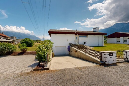 façade avec mountain view, vue sur la montagne, allée, garage intégré, et day time
