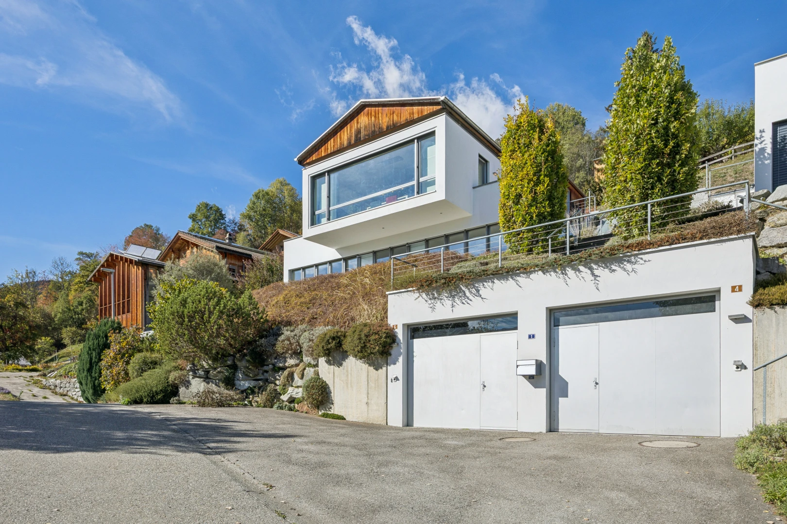außenansicht mit garage, auffahrt, stuckverkleidung, property visible, und day time