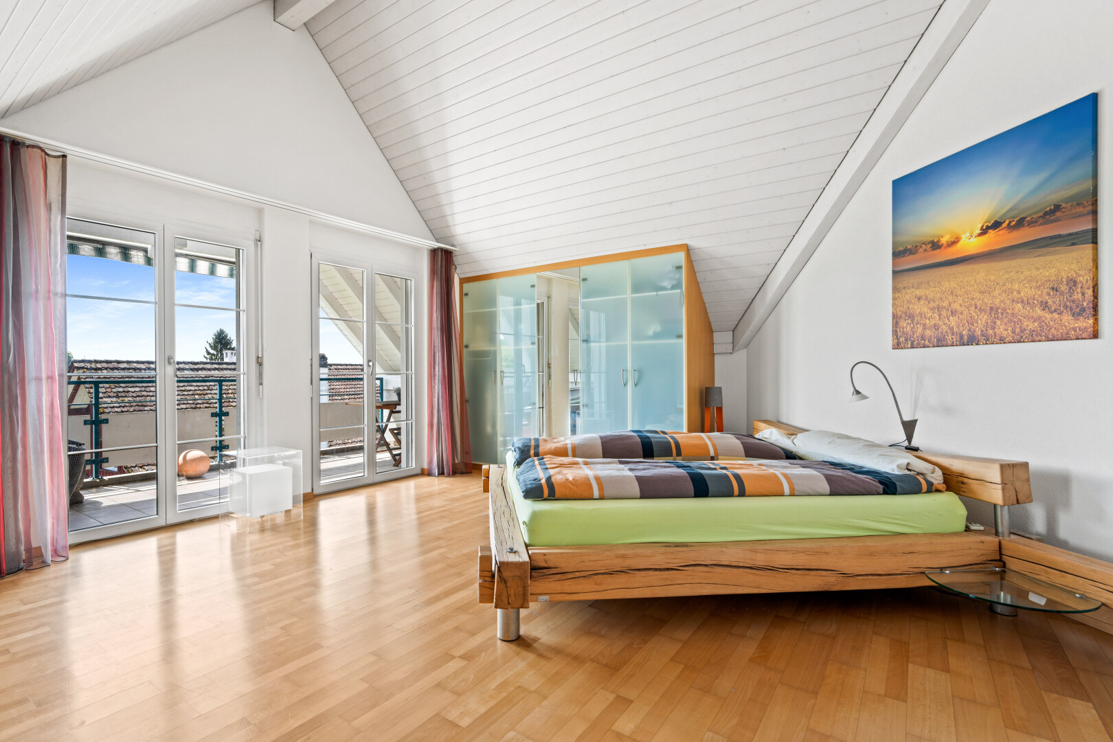 room / bedroom featuring wood finished floors, vaulted ceiling, and access to outside