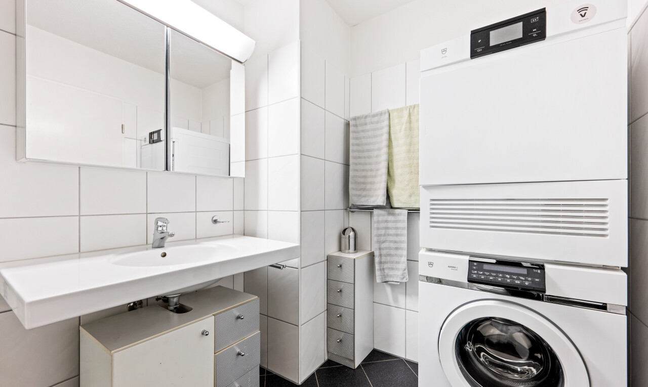 salle de bains avec miroir, lave-linge et sèche-linge superposés, sol en carrelage, tile floor, et inside property