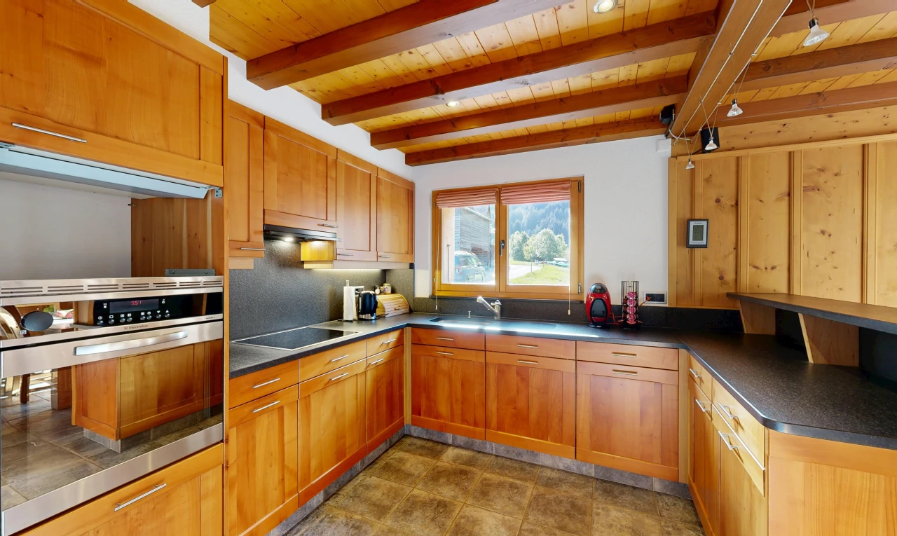 cuisine avec four, plans de travail, dark countertops, plafond à poutres, et beamed ceiling