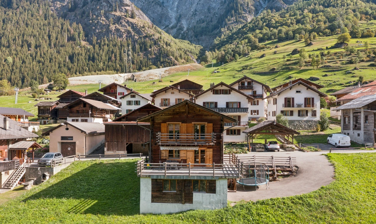 façade avec terrasse, mountain view, vue sur la montagne, pelouse, et property visible