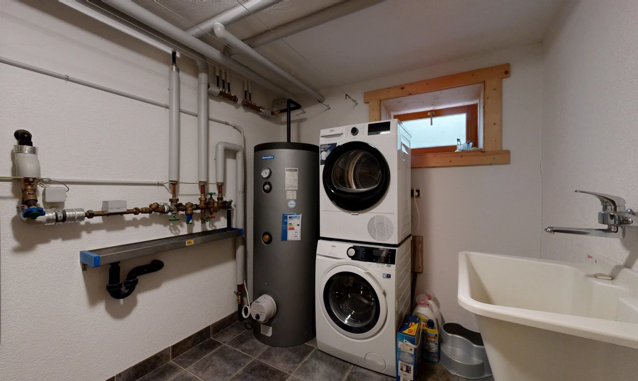 buanderie avec évier, lave-linge et sèche-linge superposés, chauffe-eau, sous-sol, et inside property