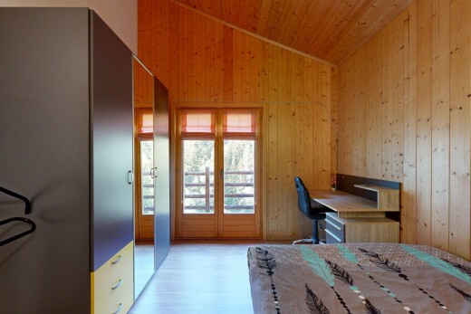 zimmer / schlafzimmer mit vaulted ceiling, dachschräge, wood wall, holzwand, und bürobereich