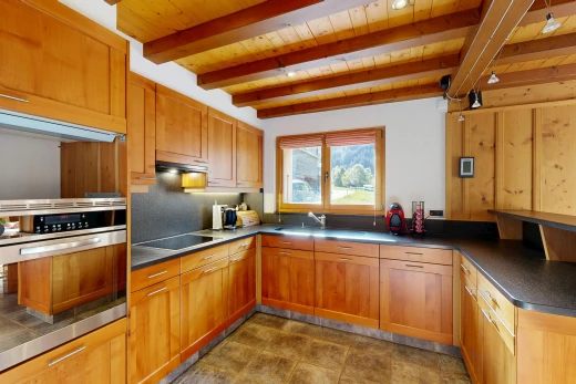 cuisine avec four, plans de travail, dark countertops, plafond à poutres, et beamed ceiling