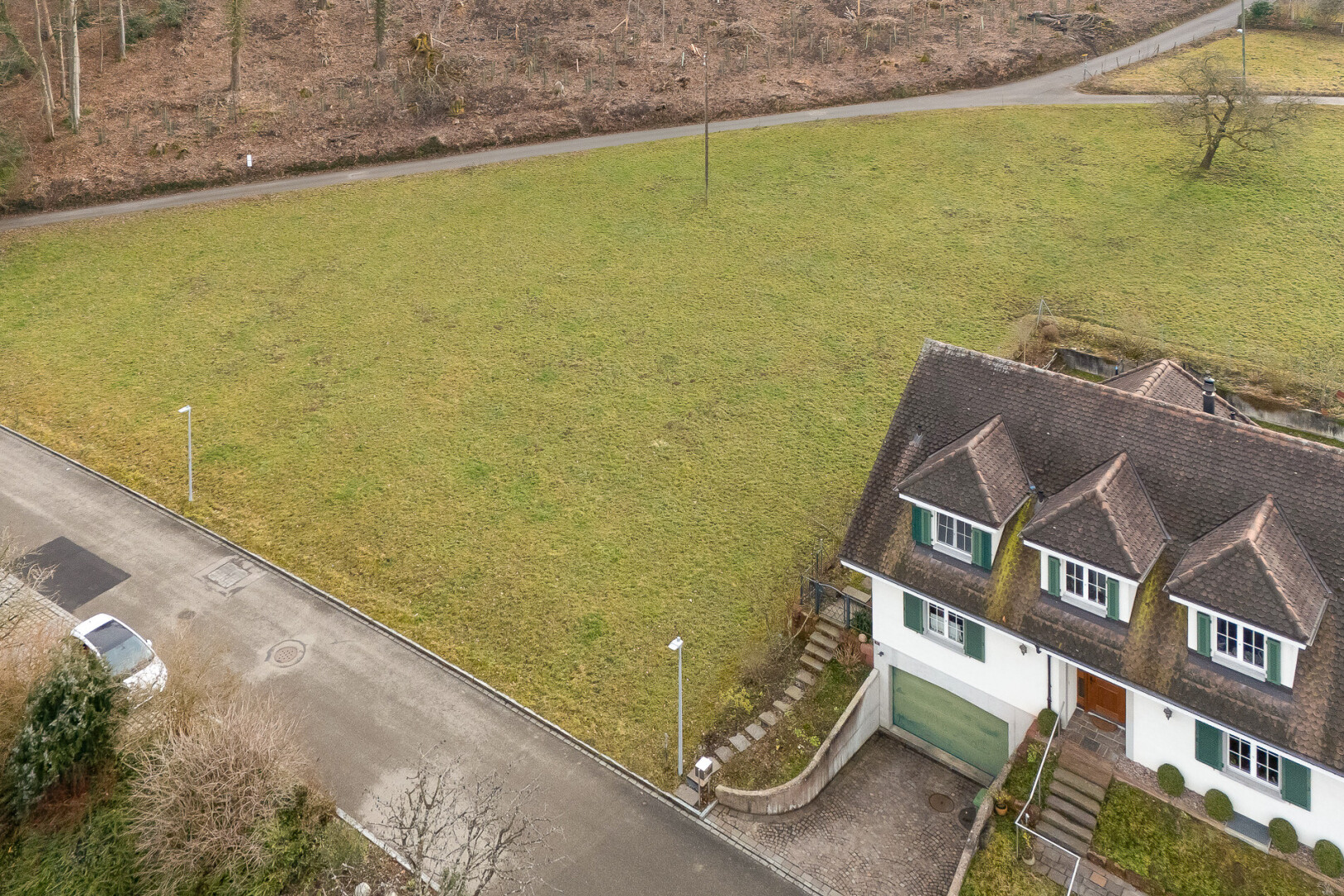 außenansicht mit eingebaute garage, dachgaube, kellergarage, und auffahrt