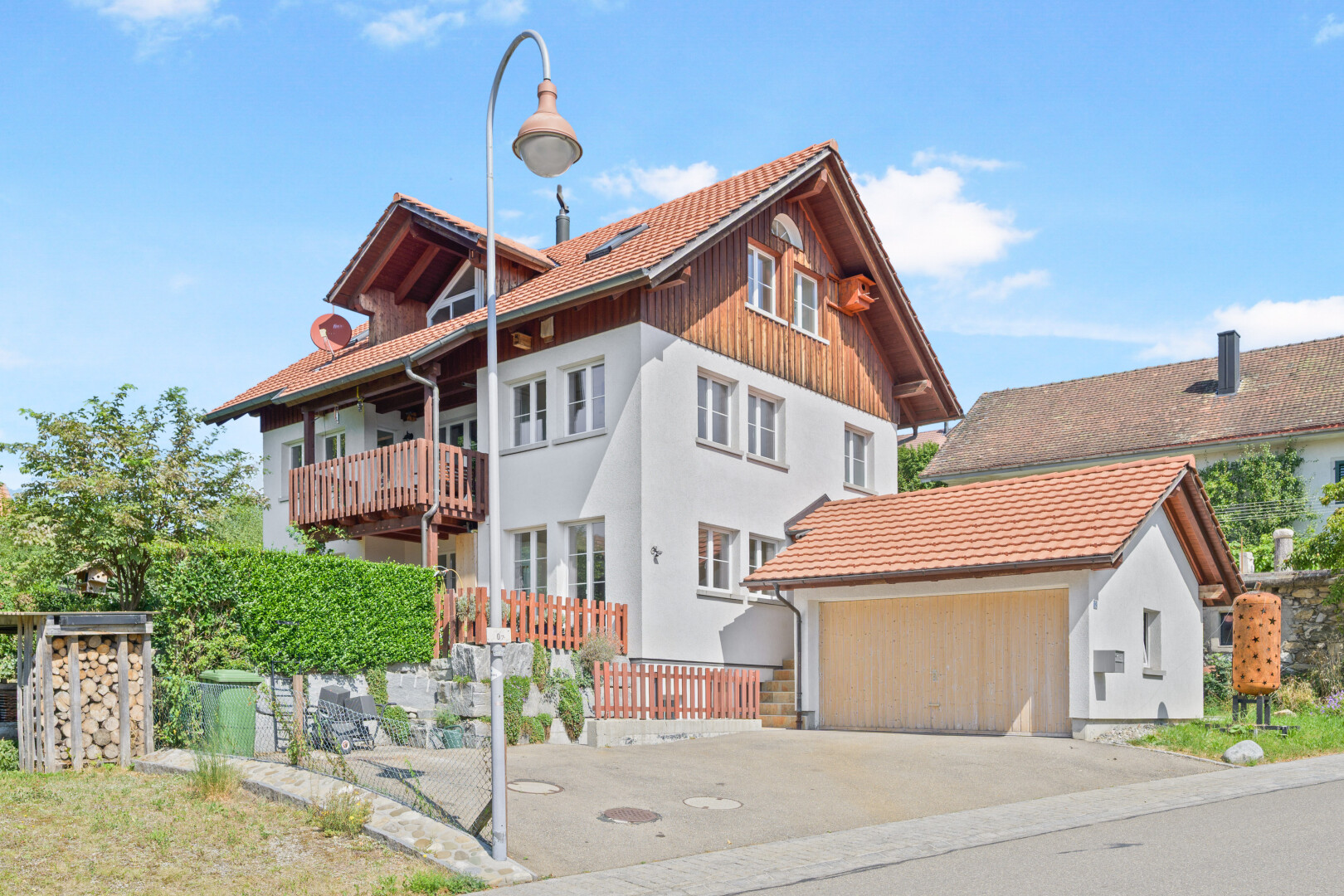 façade avec day time, garage, bardage vertical, balcon, et property visible