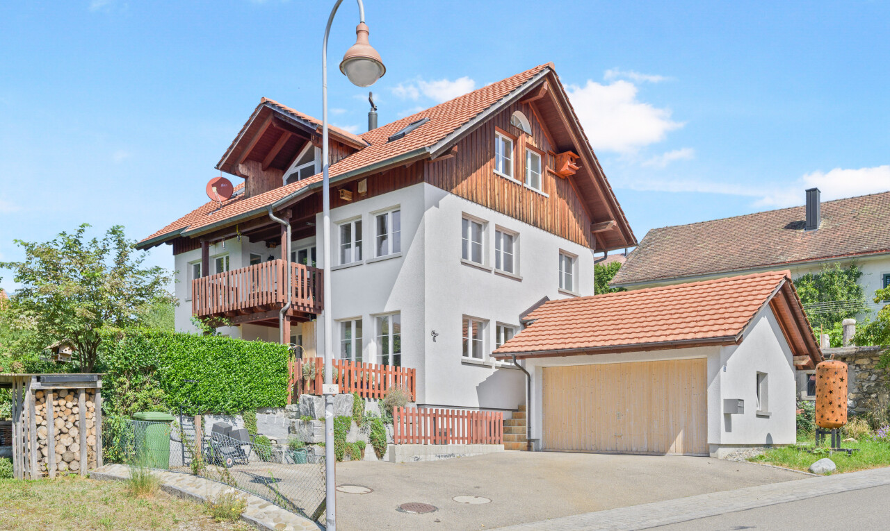 außenansicht mit day time, garage, vertikale verkleidung, balkon, und property visible