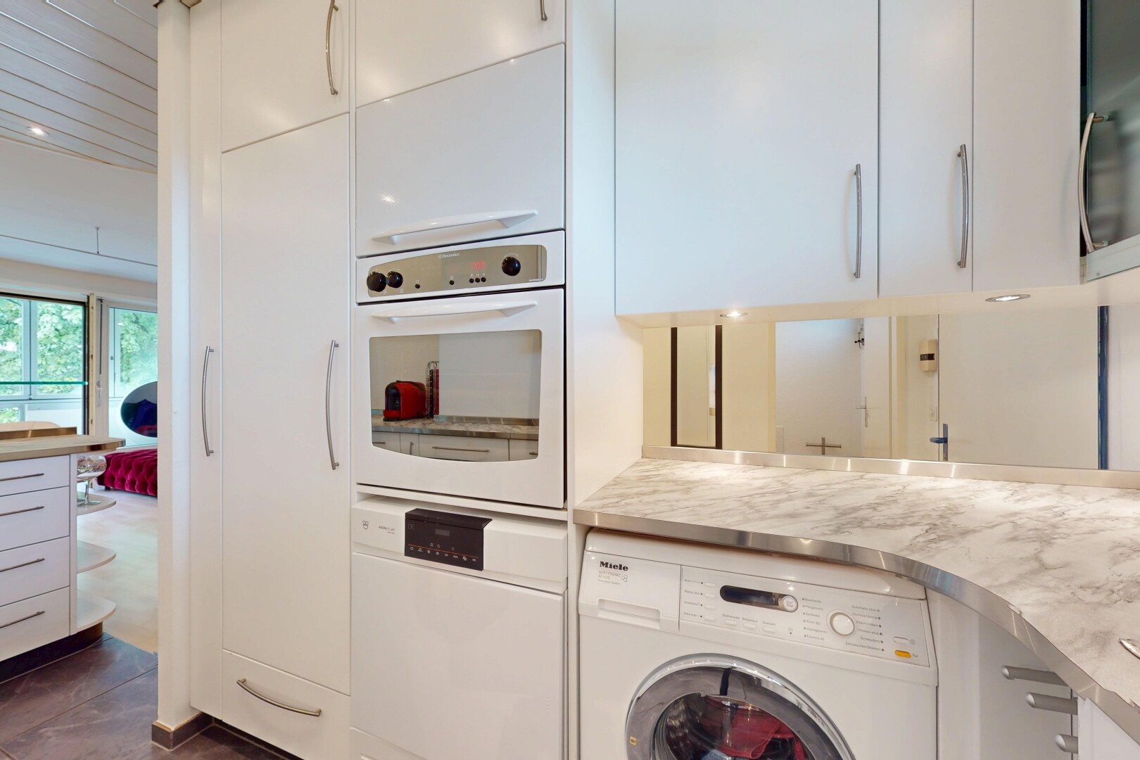 kitchen with washer / dryer, white cabinets, white appliances, and light countertops