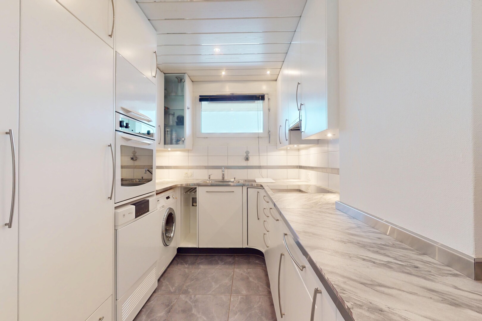 kitchen with glass insert cabinets, tasteful backsplash, white appliances, and white cabinetry