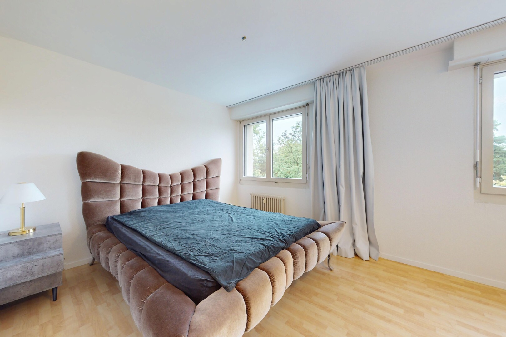 room / bedroom with wood finished floors and radiator